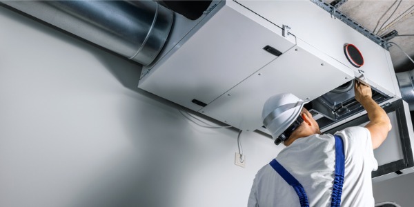 An HVAC technician working on an air conditioning unit.