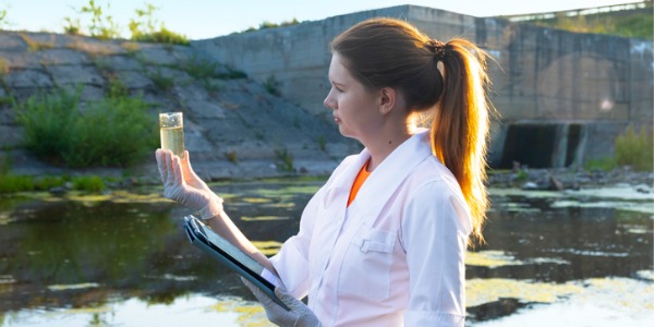 A hydrologist looking at a water sample.