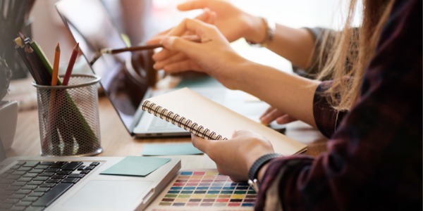 Two commercial artists looking at a colour palette for design inspiration.