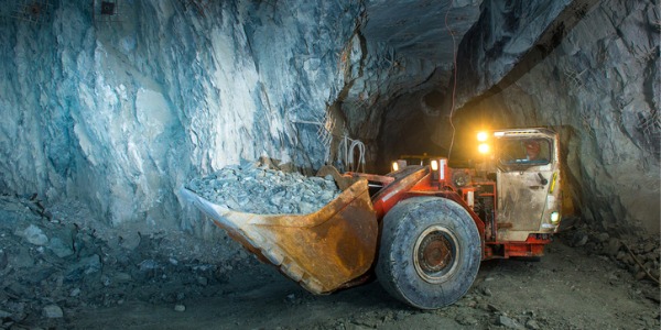 A mining machine operator operating a loader inside a mine.