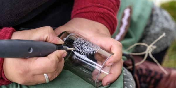 An engraver etching a design on glass.
