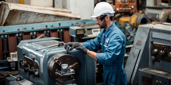 An industrial machinery mechanic repairing industrial machinery.
