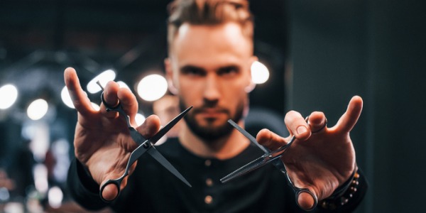 A fashion hairdresser showing the camera his scissors.