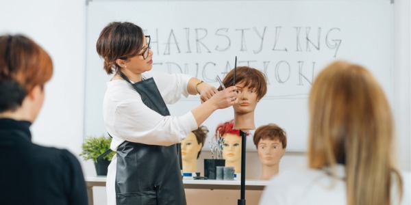 A hairdressing educator teaching a class.