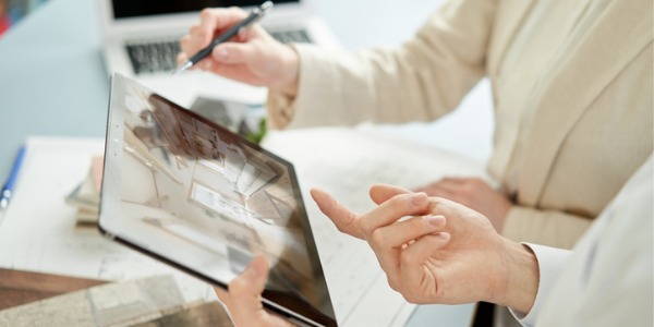 A residential interior designer showing a client a rendering.