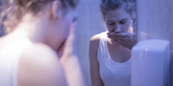 A female with an eating disorder in the bathroom.