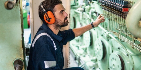 A ship engineer repairing the mechanical system onboard a ship.