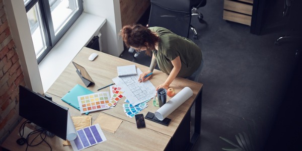 An interior decorator looking at paint samples on her desk.
