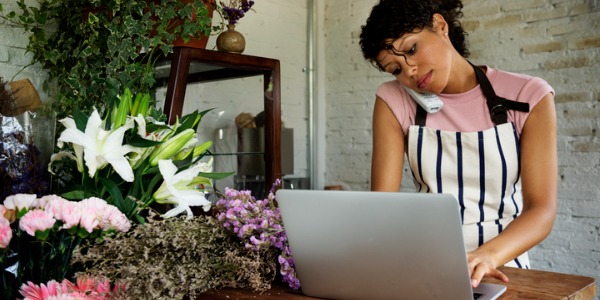 A retail florist on the phone with a customer.
