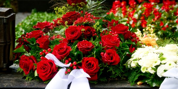 An arrangement of flowers on a casket made by a funeral florist.