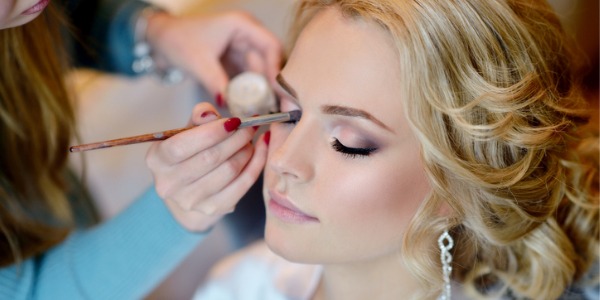 A bridal makeup artist applying makeup on a bride.