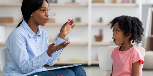 A speech language pathologist working with a little girl.