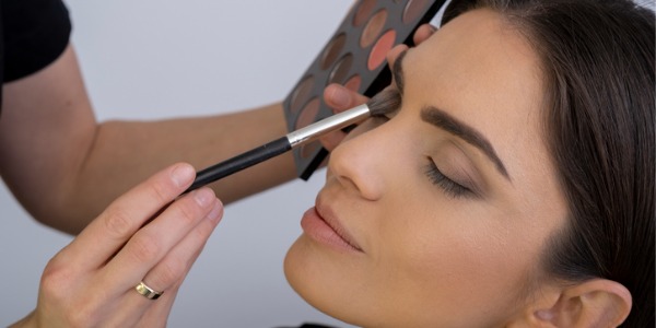 A celebrity makeup artist applying makeup on a female celebrity.