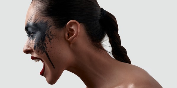 A model, displaying bold makeup applied by an editorial makeup artist, posing for a magazine spread.