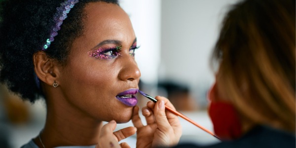 A performer getting her makeup done by a theatrical makeup artist.