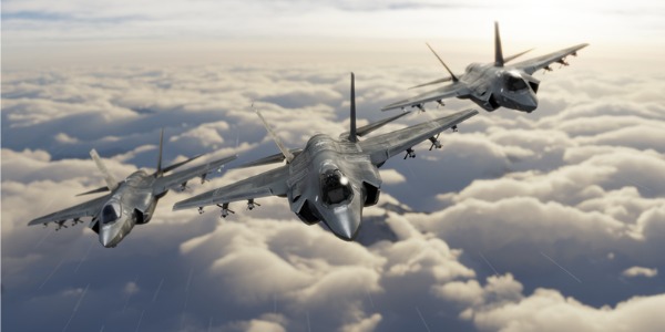 Military aircrew members flying three F-35 fighter jets.