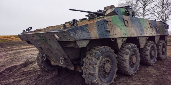 An armored assault vehicle crew member driving an assault vehicle.