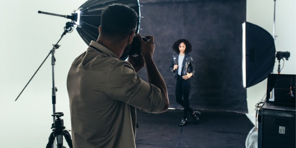 A portrait photographer taking photographs of his client.