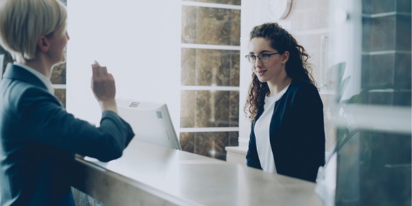 A concierge in a hotel lobby helping a guest.