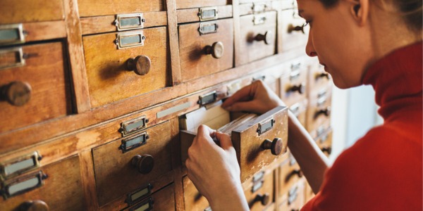 A cataloging librarian looking at filed library index cards.
