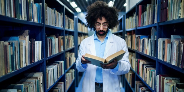 A health sciences librarian looking at medical literature in an academic medical library.