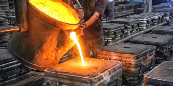 A molding and casting worker filling a mold.