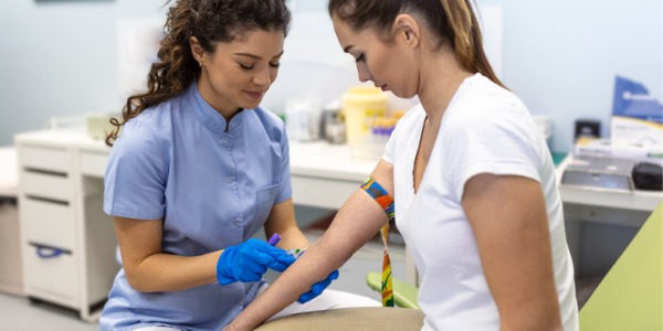 A phlebotomist drawing blood from a patient.