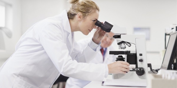 A veterinary pathologist looking through a microscope.