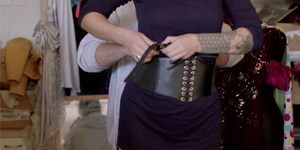 A costume attendant assisting a performer with a costume change.