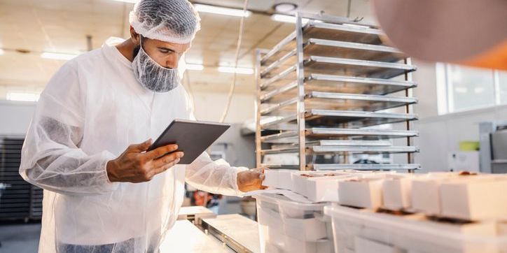 A food quality assurance technician monitoring the food quality in a processing plant.