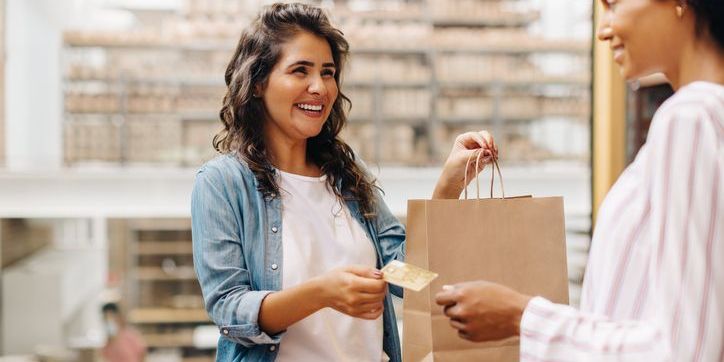 A retail salesperson helping a customer in a clothing store.