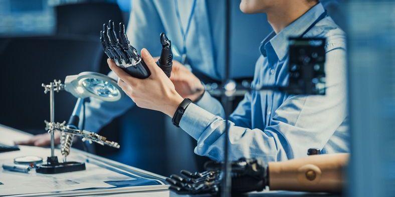A medical appliance technician working on a hand prosthetic.