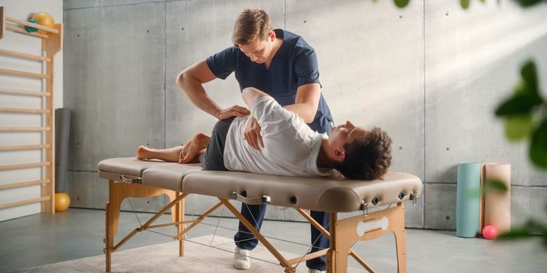An osteopath utilizing hands-on techniques to manipulate the musculoskeletal system of a patient.