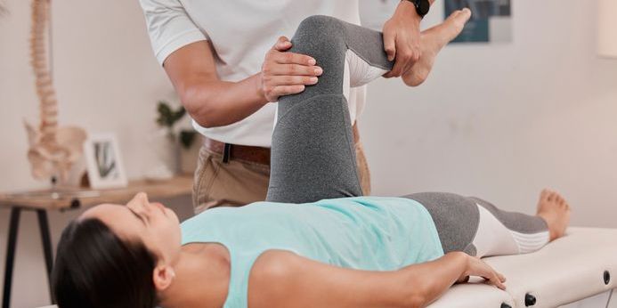 A physical therapist assistant assessing a patient's range of motion.