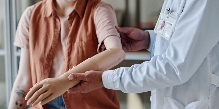 A prosthetist fitting a patient with a prosthetic arm.