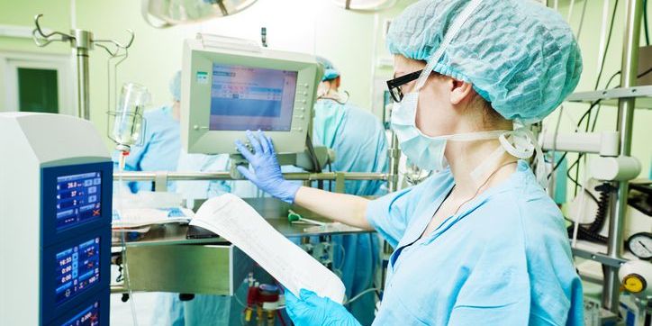 A perfusionist monitoring a heart-lung machine during cardiac surgery.