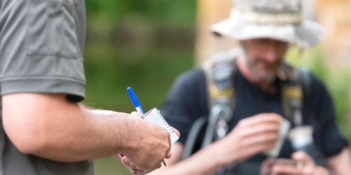 A fish and game warden issuing a ticket.