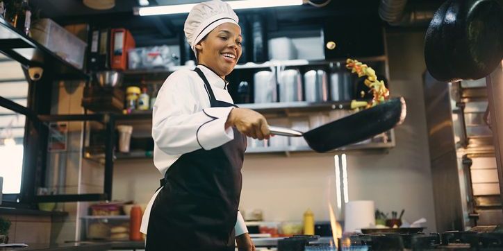 A restaurant cook sautéing vegetables.