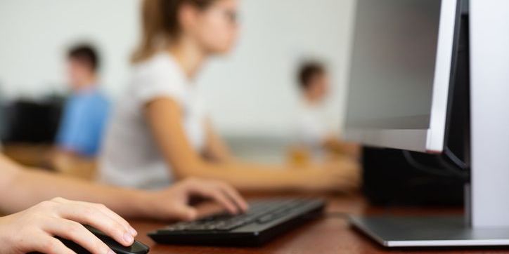 Students in a classroom on computers, their lesson being provided by educational technology.
