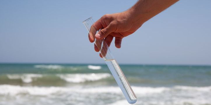 A marine biogeochemist taking a water sample from the ocean.
