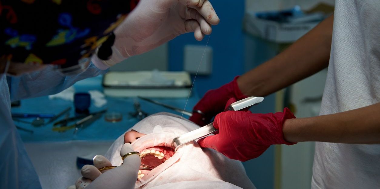 An oral and maxillofacial surgeon performing a surgery.