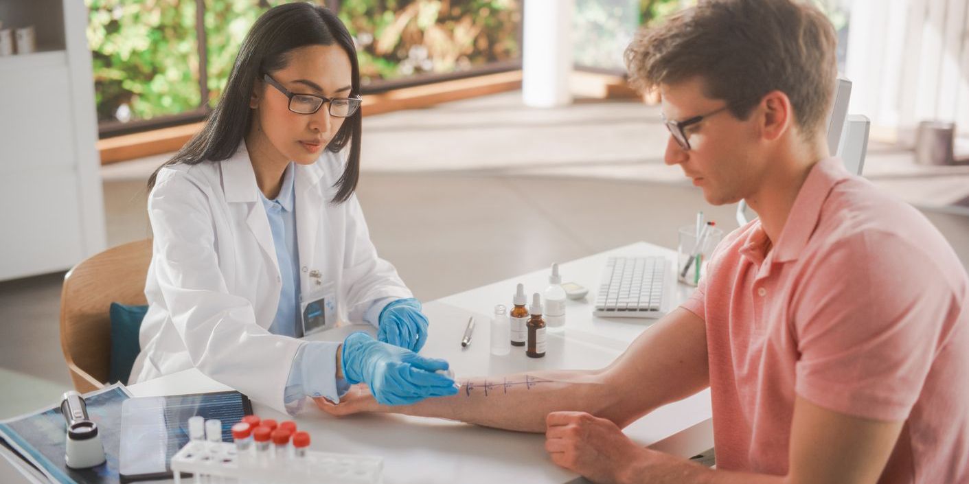 An allergist doing a skin prick allergy test on a patient's arm.