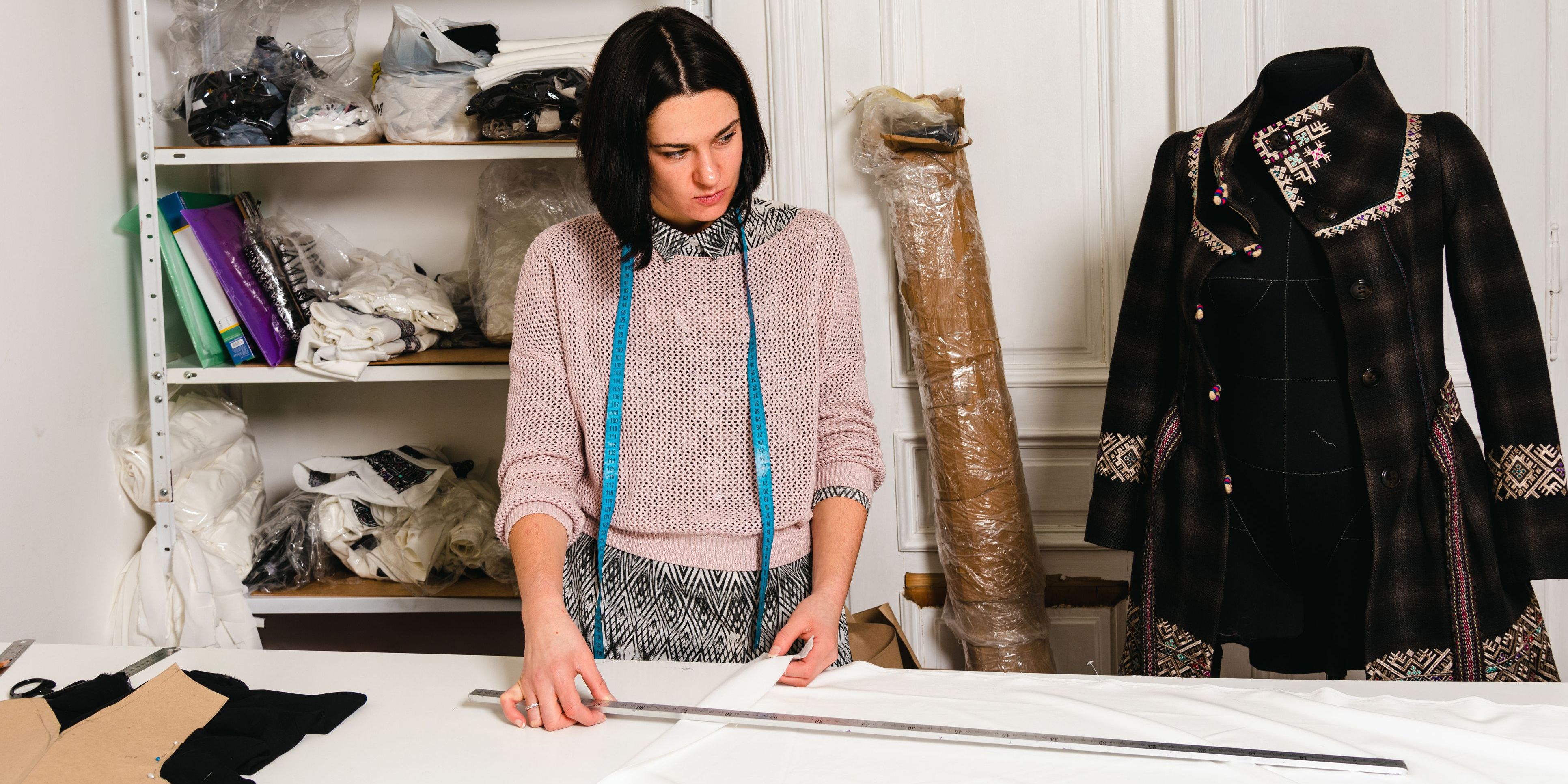 A film costume designer looking at her creation on a mannequin.