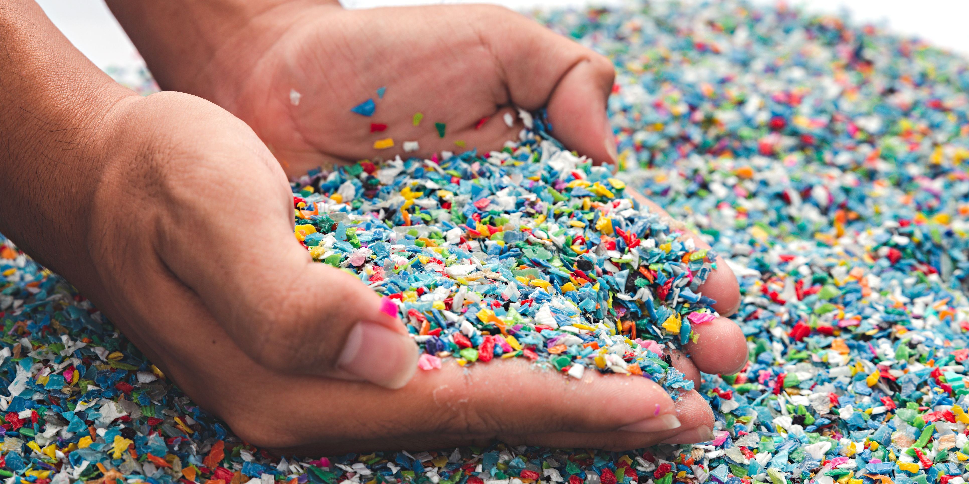 A plastics engineer holding a handful of polymer plastic pellets.