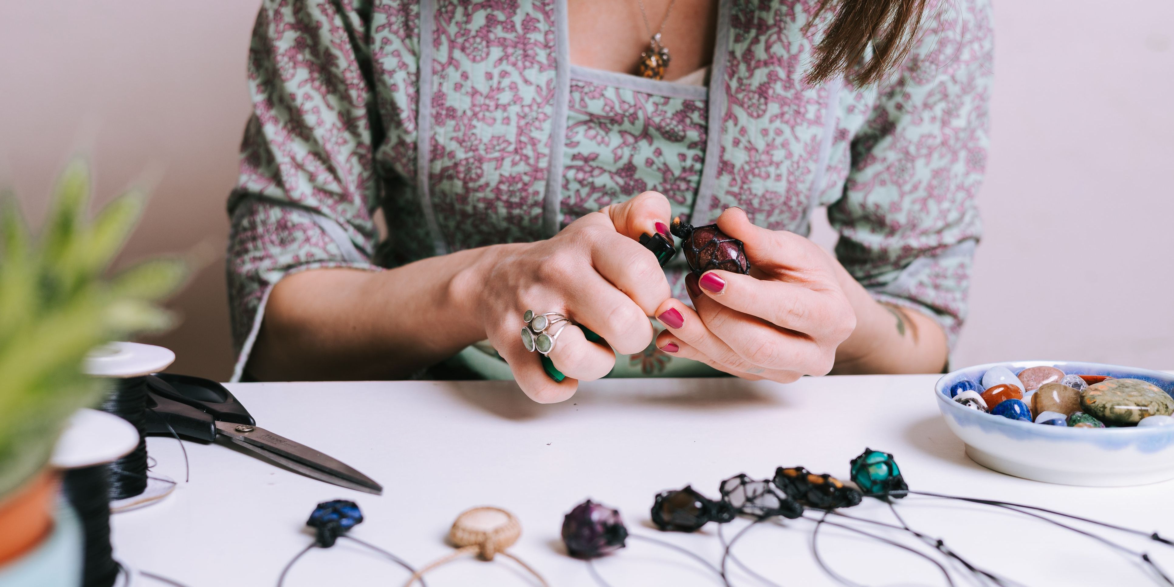 A hobbyist entrepreneur making necklaces for her side business.