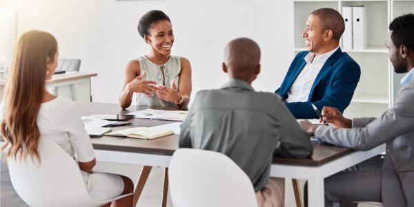 A social entrepreneur sitting with her team, creating a business that has a positive social impact.