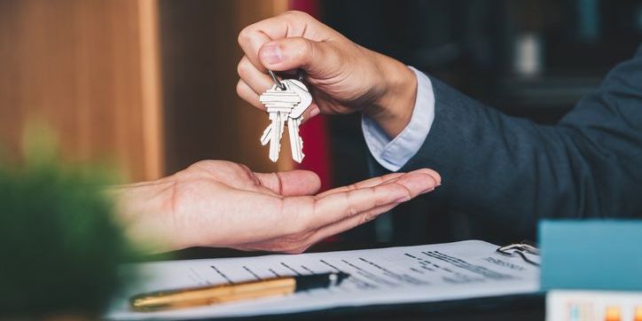 A real estate broker handing over keys to a client.