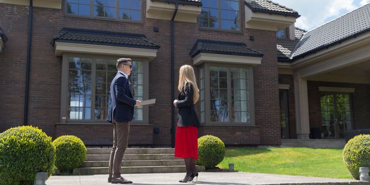 A luxury real estate agent showing a client a home.