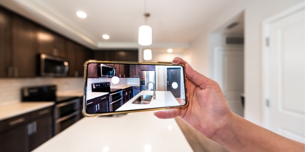 A relocation real estate agent taking a video of a kitchen for a client that lives out of state.