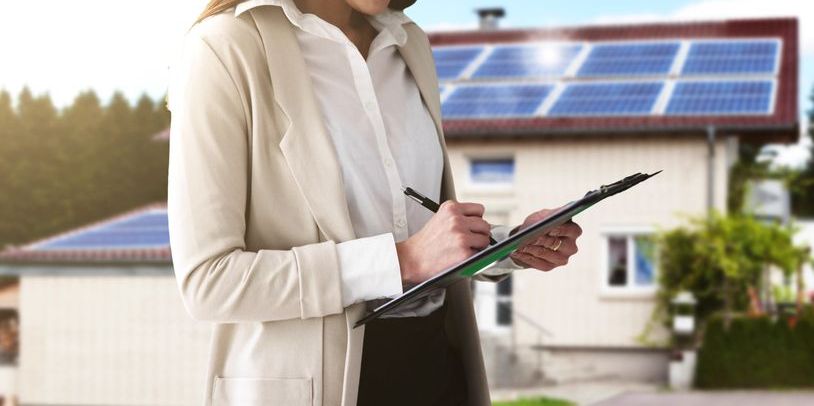 A green real estate agent outside of an eco-friendly home.